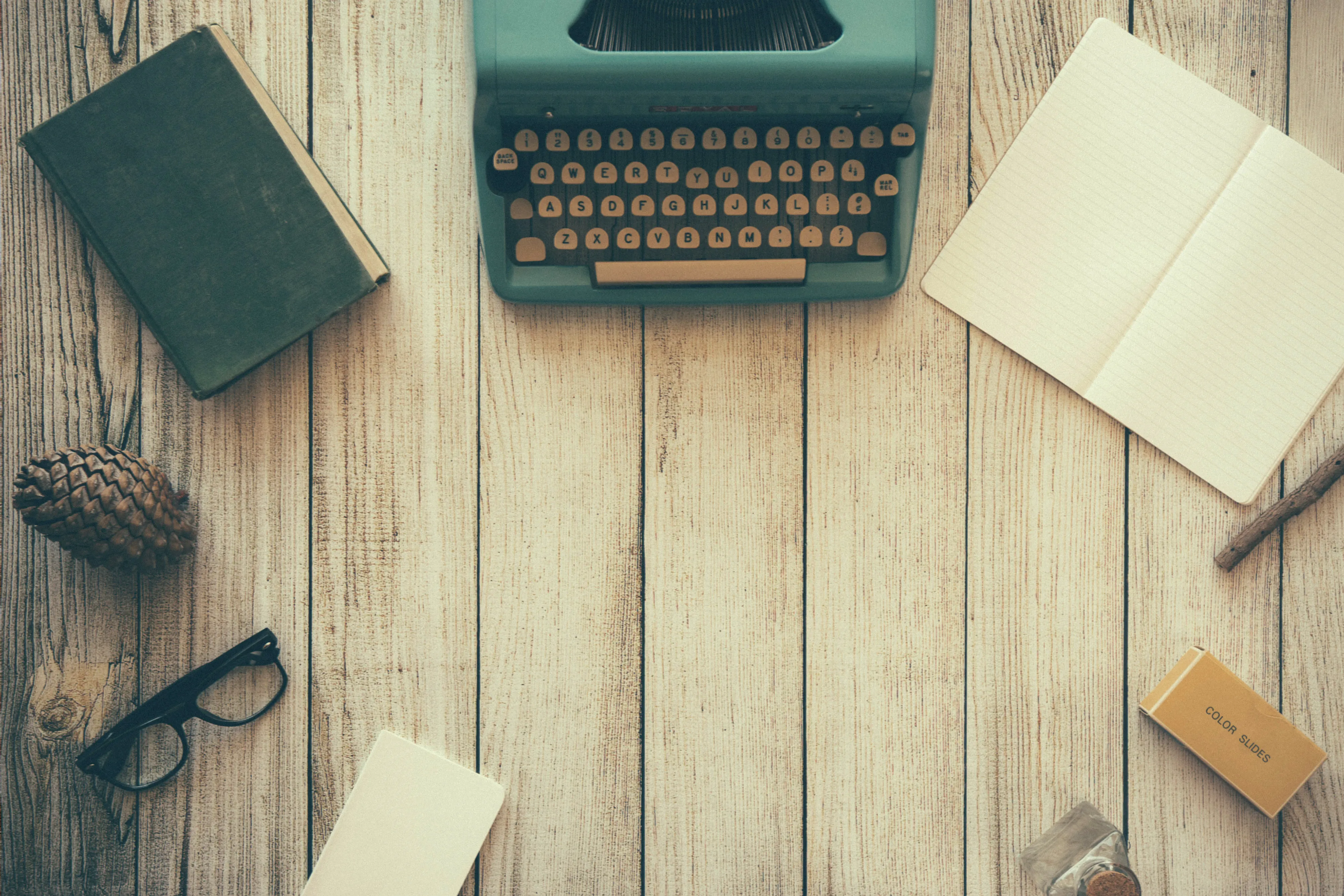 Typewriter with reading glasses on wooden desk